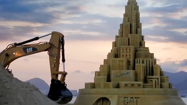 7 machines Cat à l'oeuvre sur le plus haut château de sable du monde