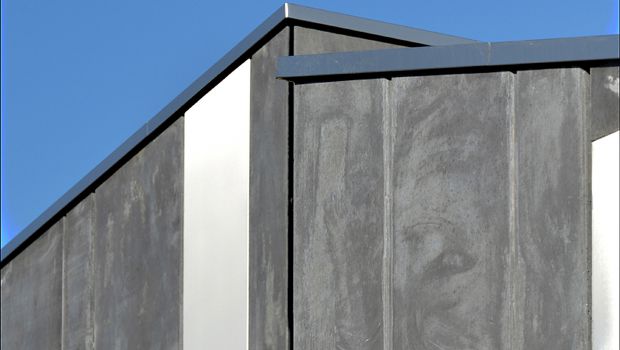 Des panneaux en béton noir incrustés de plaques inox 